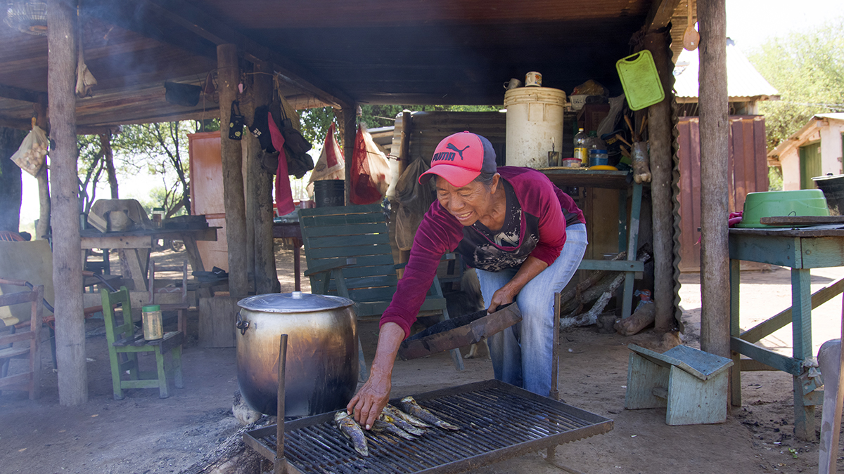 Mujer ind&iacute;gena cocinando su pesca. Solidaridad